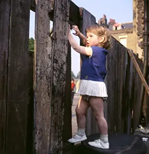 Hole Prints: Little girl climbing on a fence, Balham, SW London
