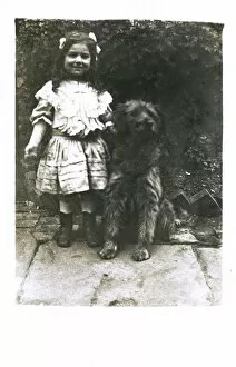 Patio Gallery: Little girl with a dog in a garden