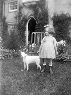 Little girl in a garden with a small dog