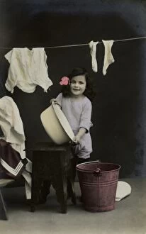 Images Dated 13th February 2012: Little girl on a postcard, hanging up the washing