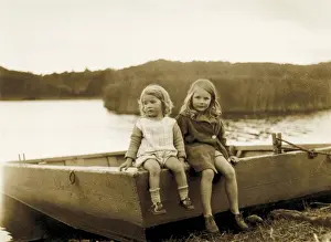 Two little girls sitting on the edge of a boat, Scotland