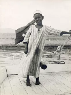 Childish Collection: The little son of a ferryman at Luxor, Egypt, steers his fathers boat with his leg