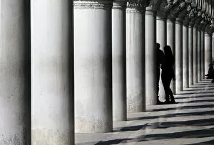 Lovers between marble pillars of the Doges Palace in Venice