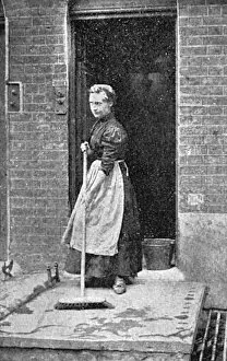 A maid-of-all-work sweeps a step, c. 1900