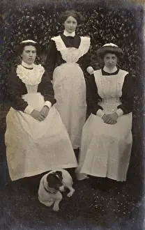 Three maids and dog in garden