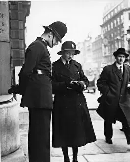 Male and female police officer on a street, London