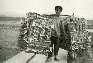 Man carrying imitation paper money, China, East Asia