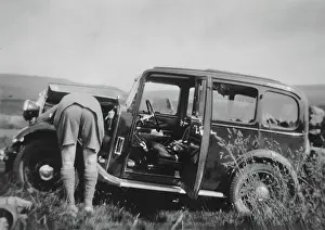 Bonnet Prints: Man checking car engine in a field