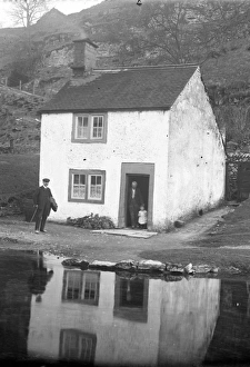 Man and child at door of riverside cottage in Alport, Derbys Man and child at door of riverside cottage in Alport, Derbys