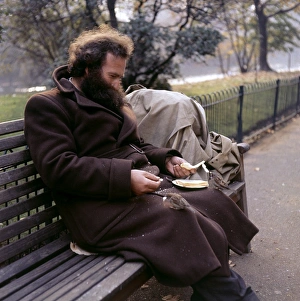 Sparrow Gallery: Man feeding sparrow in a Balham park, SW London
