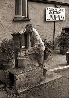 Man filling a bucket at a water pump