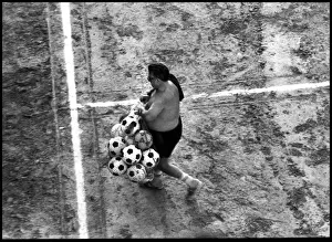 Man with footballs on training pitch, Spain