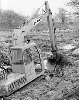 Man with mechanical digger in a muddy field