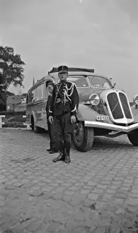 Man in military uniform standing by a coach