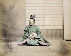 A man, possibly a government official, holding a fan, seated