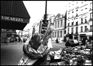 Man in street with baguettes, Paris, France