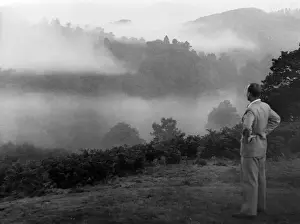 Grasmere Prints: A man in a suit stops to look at the impressive morning mist over Grasmere, Lake District