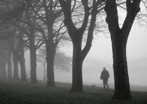 Images Dated 22nd July 2019: Man walks his dog in thick fog along banks of the River Dee