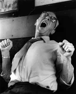 Man yawning and stretching on a train