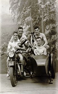 Prop Collection: Four men on a 1931 / 32 Raleigh motorcycle holding beer bottle