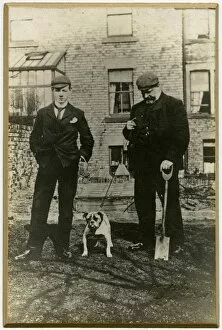 Two men with bulldog in a back garden