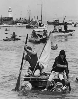 Two men competing in a raft race, St Ives, Cornwall