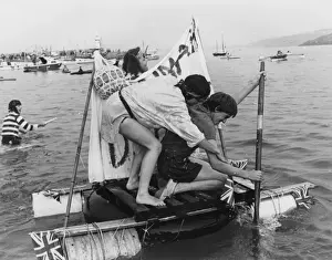 Two men competing in a raft race, St Ives, Cornwall