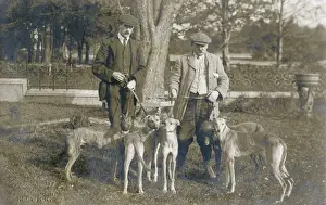 Two men with five dogs in a garden