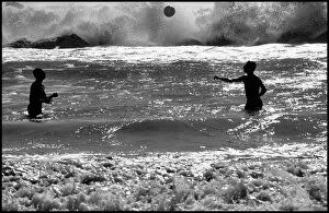 Images Dated 6th October 2015: Men playing with a ball in heavy surf