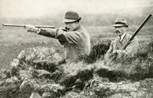 Two men shooting grouse from butts on an English moor
