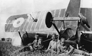 Four men with upturned biplane in field, WW1