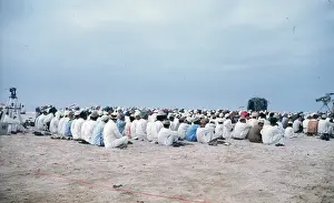 Backs Prints: Men and young boys sitting on the beach in Oman