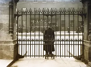 Met Police officer looking through iron gates