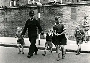 Metropolitan Police officer and children crossing road