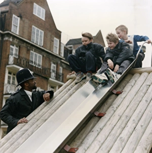 Images Dated 4th February 2011: Metropolitan Police officers with boys on slide