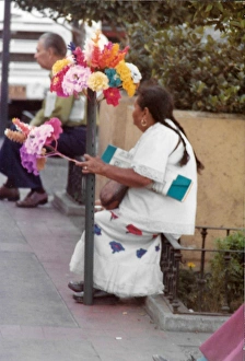 Images Dated 25th July 2016: Mexican woman sitting with paper tissue flower arrangments