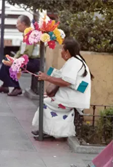 Tissue Prints: Mexican woman sitting with paper tissue flower arrangments