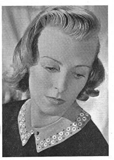 Buttoned Collection: Model wearing a blouse with a collar decorated in buttons. Date: 1940