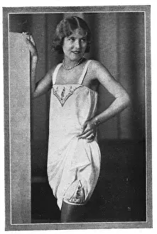 Model wearing embroidered chemise over embroidered long knickers and stockings Date: 1920s
