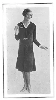 Model wearing a short-skirted afternoon frock and a string of pearl beads Date: 1930