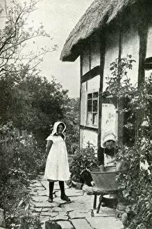 Calm Gallery: Mother and daughter outside a thatched cottage, England