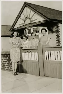 Mother and daughters by the gate of a lovely bungalow