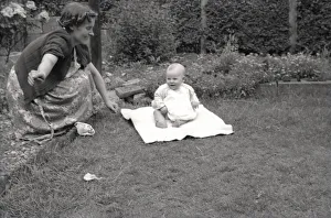 Mother and her young baby playing out in the garden