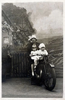 Siblings Collection: Mother and her two young children - studio photo on bike