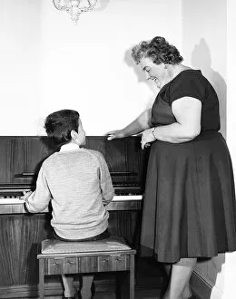 Encouraging Collection: Mrs Mills, celebrity pianist, with boy at piano