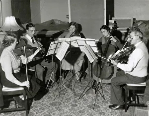 Recital Prints: A musical quintet rehearse a piece of classical music. Date: 1930s