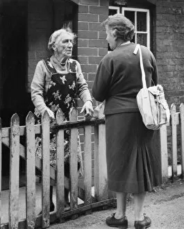 Images Dated 26th May 2017: Two neighbours chatting over a fence