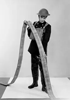 Removing Prints: NFS firefighter under-running a fire hose, WW2