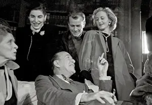 Judy Prints: Noel Coward sits relaxed surrounded by 4 smiling standing cast members during rehearsals of play Relative Values which