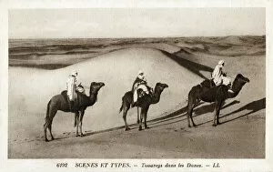 Images Dated 22nd April 2021: Nomadic Tuaregs riding camels amongst the Saharan Dunes - North Africa